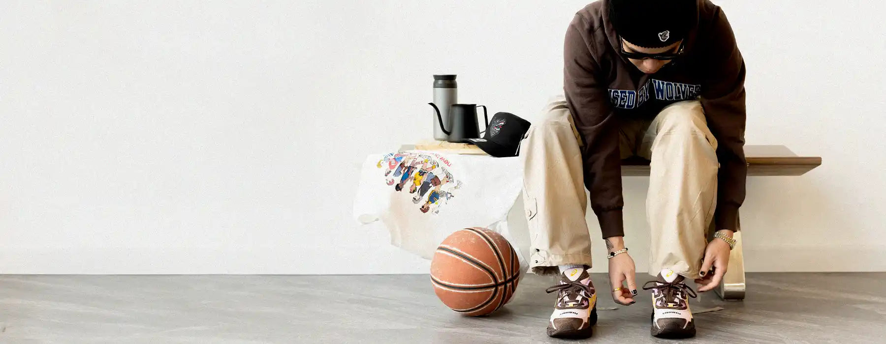 Basketball resting on a gray floor next to someone’s feet.